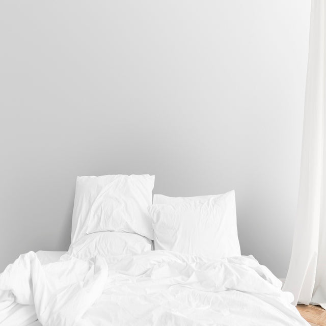 White bed linen in a bed in a bedroom